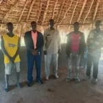 Detained civilians pose for a group photo with County Commissioner OKuba-Photo credit: Press Unity Morobo County