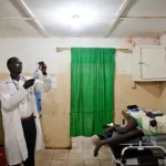 Medical worker admitting medication to a patient in Yei civil hospital