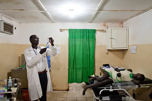 Medical worker admitting medication to a patient in Yei civil hospital