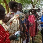 WFP staff reading a cash voucher presented by a beneficiary receiving Anticipatory cash assistance in Kapoeta North County, Eastern state. Photo Credit: WFP/ Gabriela Vivacqua
