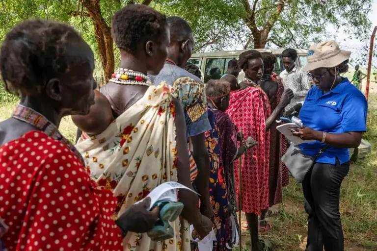 WFP staff reading a cash voucher presented by a beneficiary receiving Anticipatory cash assistance in Kapoeta North County, Eastern state. Photo Credit: WFP/ Gabriela Vivacqua