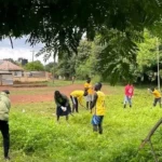 Atlabara FC players cleaning an area behind Youth Gardens
