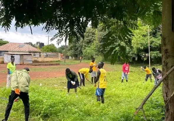 Atlabara FC players cleaning an area behind Youth Gardens