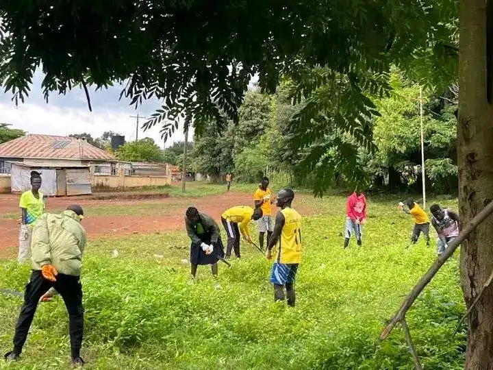 Atlabara FC players cleaning an area behind Youth Gardens