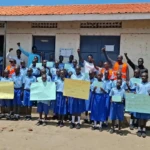 Pupils pose for a photo with teachers and staff from Human Foundation for Humanity after the debate