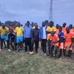 Football players and local officials pose for a group photo in Morobo County