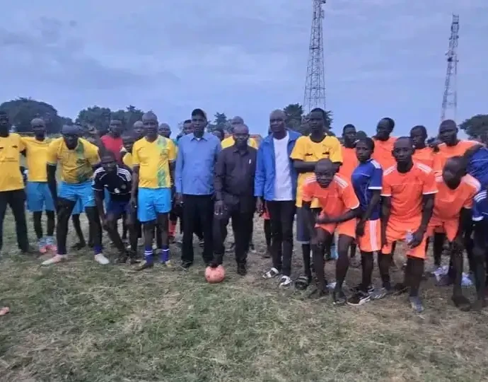 Football players and local officials pose for a group photo in Morobo County