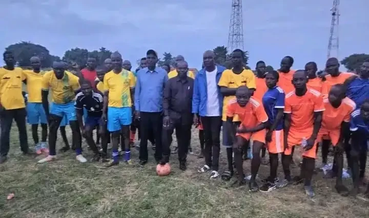 Football players and local officials pose for a group photo in Morobo County